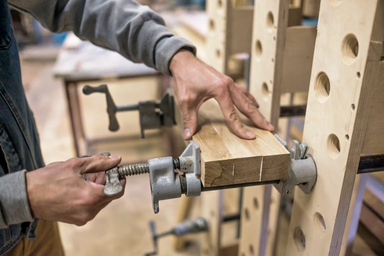 Using clamps and glue to connect wooden timbers for furniture detail